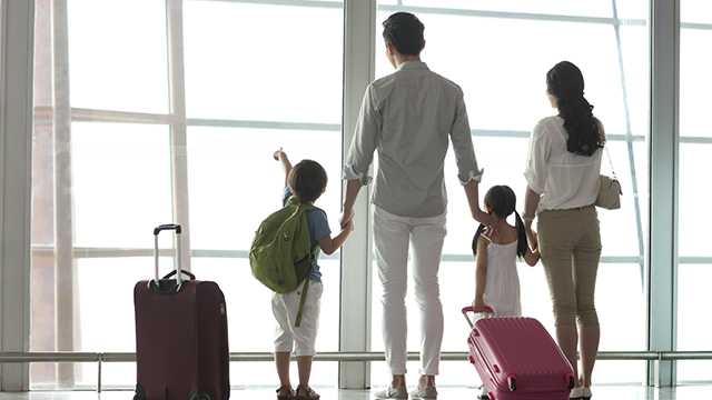 Family is ready for their trip at the airport with packed travel toothbrush and toothpaste