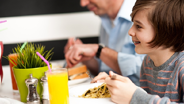 Smiling Kid with Braces eating pasta 