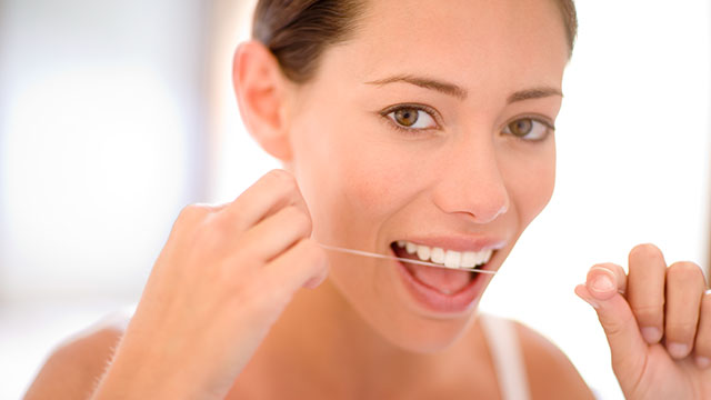woman using dental floss