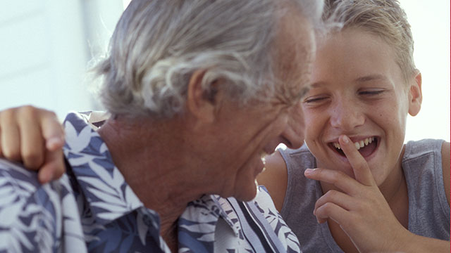 Grandfather and grandson laughing together.